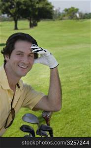 Portrait of a mid adult man smiling with golf clubs