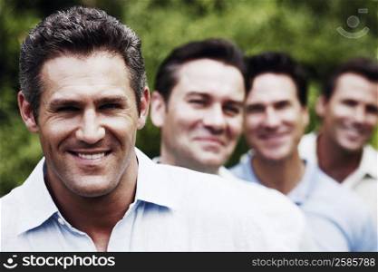 Portrait of a mid adult man smiling with his friends in the background