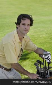 Portrait of a mid adult man standing with a golf bag