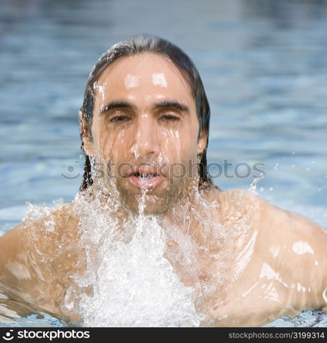 Portrait of a mid adult man swimming in a swimming pool