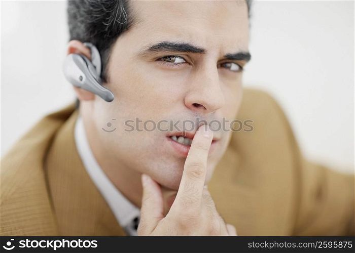 Portrait of a mid adult man thinking with finger on his lips