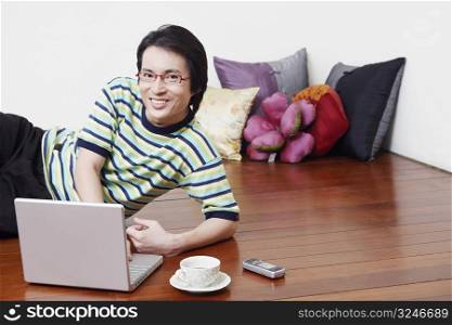 Portrait of a mid adult man using a laptop and smiling