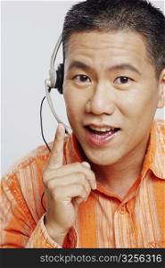 Portrait of a mid adult man wearing a headset and pointing