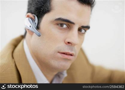 Portrait of a mid adult man wearing hands free device and thinking
