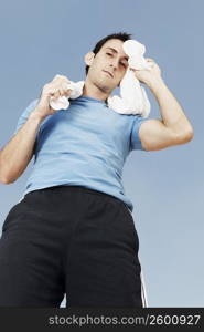 Portrait of a mid adult man wiping his face with a towel