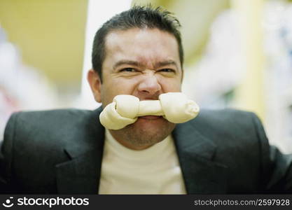 Portrait of a mid adult man with a dog bone in his mouth