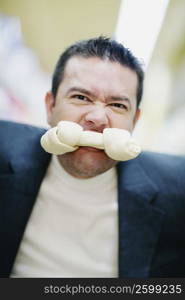 Portrait of a mid adult man with a dog bone in his mouth