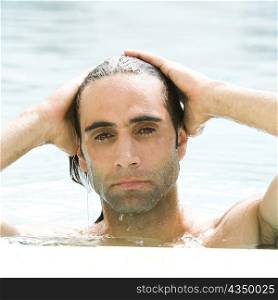 Portrait of a mid adult man with his hands on his head in a swimming pool