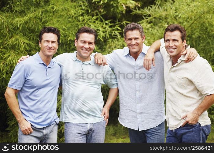 Portrait of a mid adult man with three mature men posing and smiling
