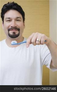 Portrait of a mid adult man with toothbrush in front of his mouth