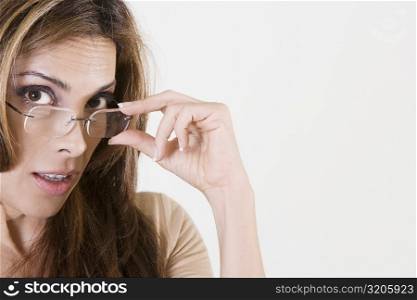 Portrait of a mid adult woman adjusting her eyeglasses