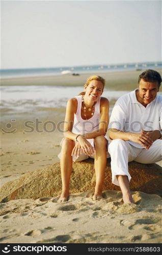 Portrait of a mid adult woman and a mature man sitting on the beach