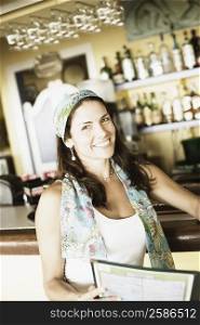 Portrait of a mid adult woman at a bar counter and smiling