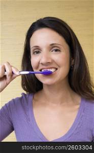 Portrait of a mid adult woman brushing her teeth