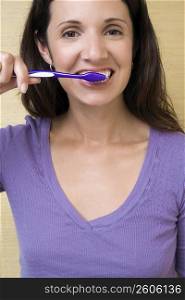 Portrait of a mid adult woman brushing her teeth