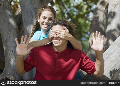 Portrait of a mid adult woman covering a mid adult man&acute;s eyes from behind