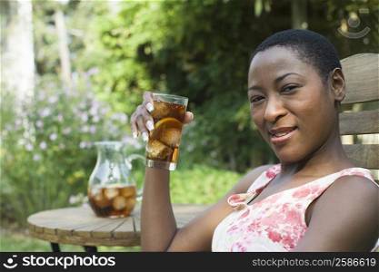 Portrait of a mid adult woman drinking ice tea and smiling