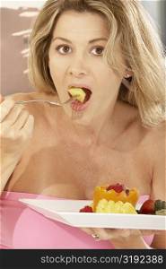 Portrait of a mid adult woman eating a papaya