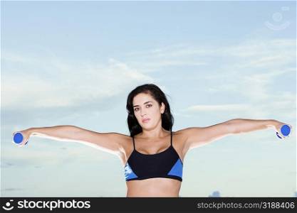 Portrait of a mid adult woman exercising with dumbbells