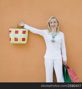 Portrait of a mid adult woman holding a bag and smiling