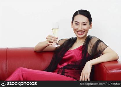 Portrait of a mid adult woman holding a champagne flute and smiling