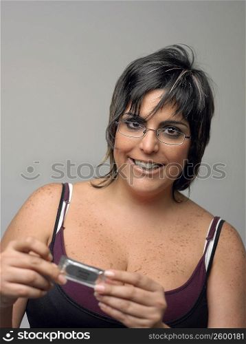 Portrait of a mid adult woman holding a condom