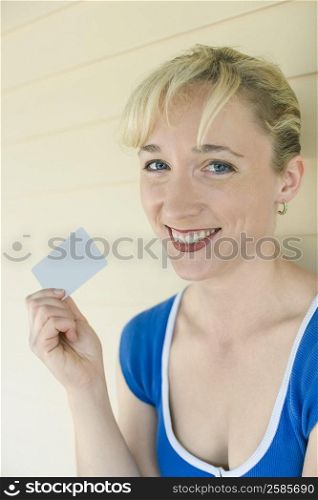 Portrait of a mid adult woman holding a credit card and smiling