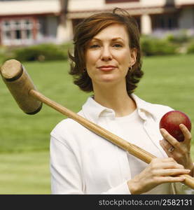 Portrait of a mid adult woman holding a croquet mallet and a ball