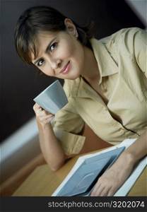 Portrait of a mid adult woman holding a cup and smiling