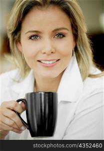 Portrait of a mid adult woman holding a cup and smiling