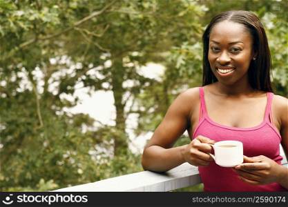 Portrait of a mid adult woman holding a cup of tea and smiling