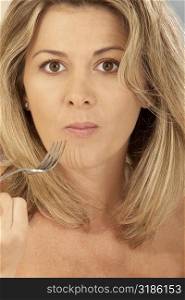 Portrait of a mid adult woman holding a fork