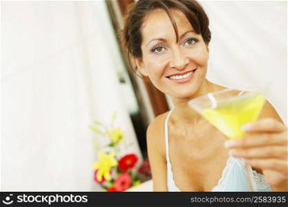 Portrait of a mid adult woman holding a glass of juice