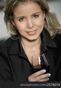 Portrait of a mid adult woman holding a glass of red wine