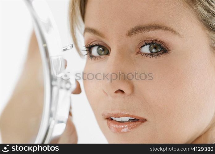 Portrait of a mid adult woman holding a pair of eyebrow tweezers