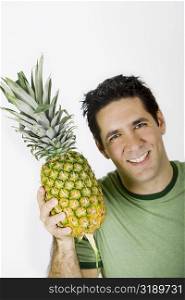 Portrait of a mid adult woman holding a pineapple and smiling