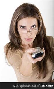 Portrait of a mid adult woman holding a remote control