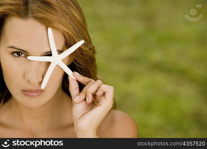 Portrait of a mid adult woman holding a star fish
