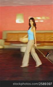 Portrait of a mid adult woman holding a suitcase and walking