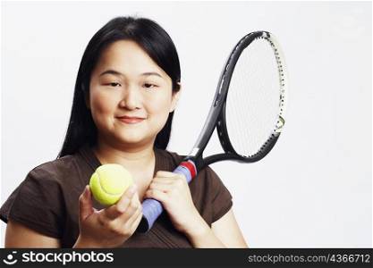 Portrait of a mid adult woman holding a tennis ball and a tennis racket