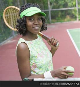 Portrait of a mid adult woman holding a tennis racket and a tennis ball
