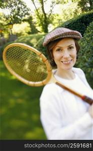 Portrait of a mid adult woman holding a tennis racket and smiling