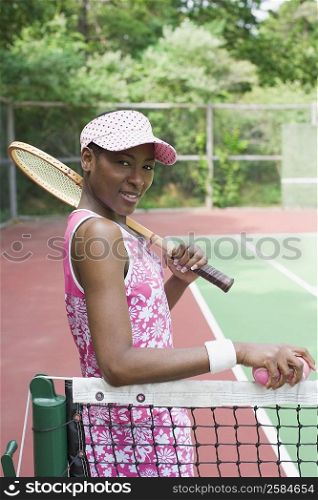 Portrait of a mid adult woman holding a tennis racket and tennis balls