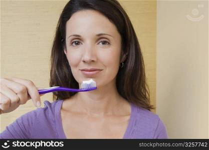Portrait of a mid adult woman holding a toothbrush in front of her mouth