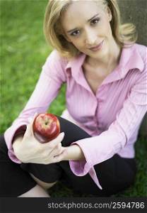 Portrait of a mid adult woman holding an apple
