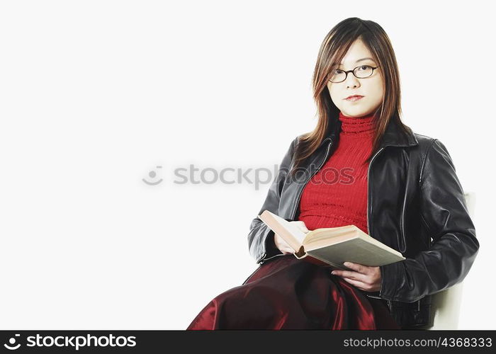 Portrait of a mid adult woman holding an open book