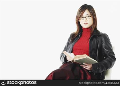 Portrait of a mid adult woman holding an open book