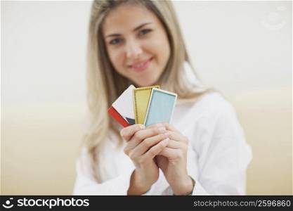 Portrait of a mid adult woman holding credit cards and smiling