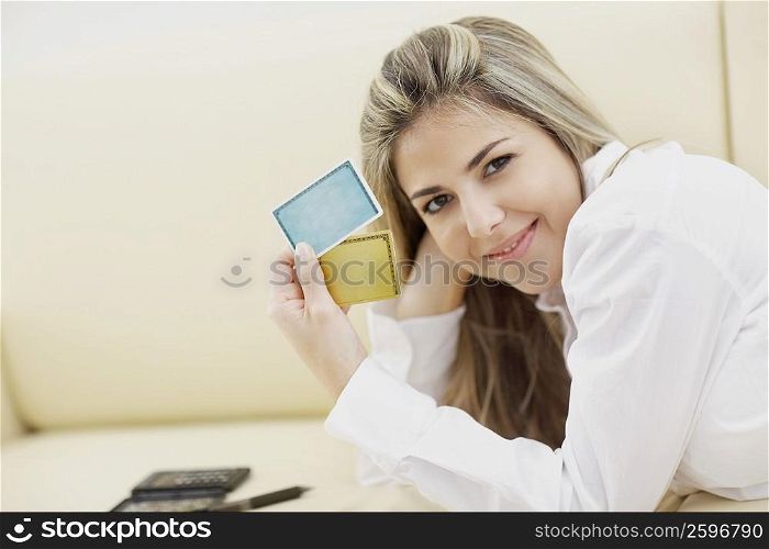 Portrait of a mid adult woman holding two credit cards and smiling