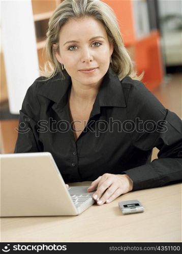 Portrait of a mid adult woman in front of a laptop